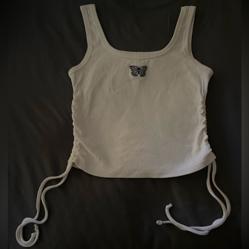 White tank top with blue butterfly in the middle